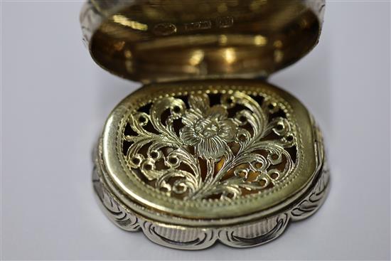 A Victorian silver cusped oval vinaigrette by Nathaniel Mills, the lid engraved with houses,